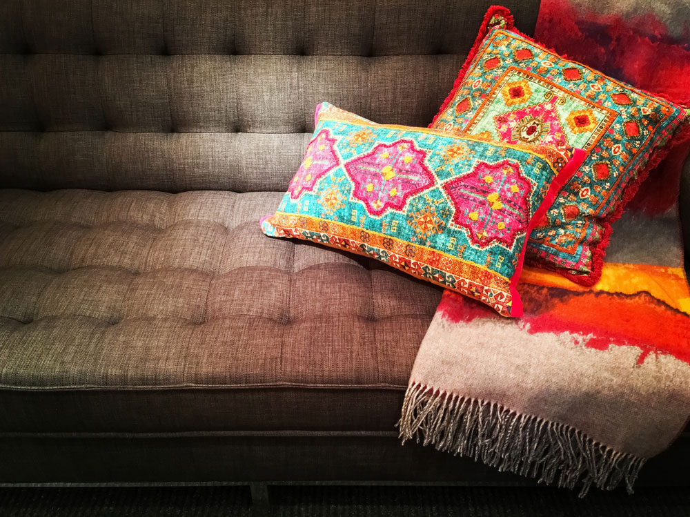 Brightly colored pillows and blanket on couch Interior Design Ellecor Bohemian