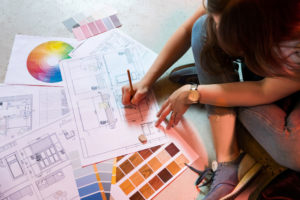 A woman draws up interior design plans Ellecor Interior Design