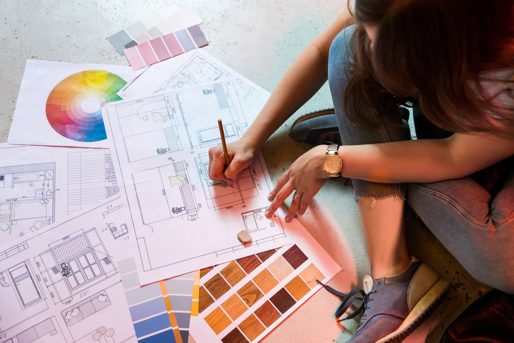 A woman draws up interior design plans. 
