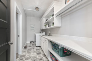 laundry room with tile floor and long countertop abby-farm-house-20