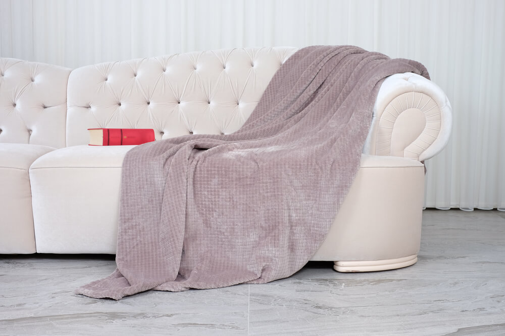 throw blanket draper over couch, fluffy and pink, white couch