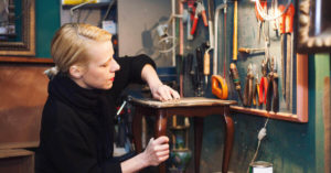 woman repairing vintage coffee table